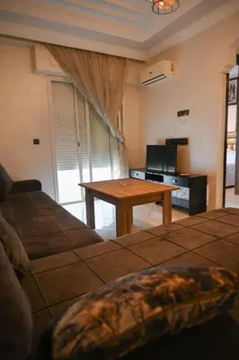 a living room with a table and a couch at Appart hotel ali in Marrakech