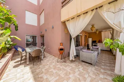 a patio with a table and chairs and a living room at Atlas view apartment in Marrakech