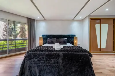 a bedroom with a large bed with a large window at Atlas view apartment in Marrakech
