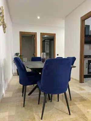 a dining room with a table and blue chairs at Appartement prestige gueliz in Marrakech
