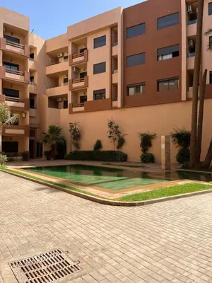 an apartment complex with a swimming pool in front of a building at Appartement prestige gueliz in Marrakech