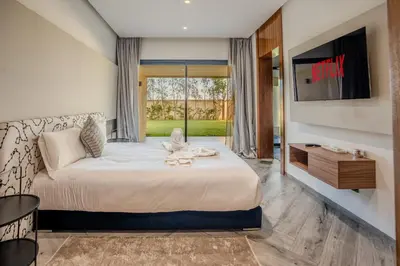 a hotel room with a bed and a tv at Villa Illao 2 Pool, Jacuzzi & Cinéma in Marrakech