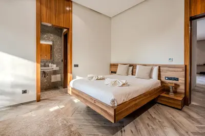 a bedroom with a large bed and a bathroom at Villa Illao 2 Pool, Jacuzzi & Cinéma in Marrakech