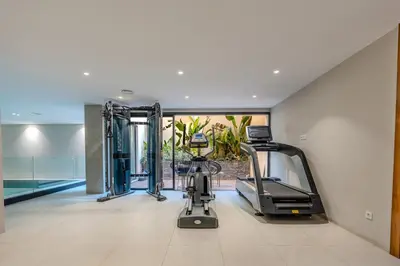 an exercise room with a treadmill and a swimming pool at Villa Illao 2 Pool, Jacuzzi & Cinéma in Marrakech