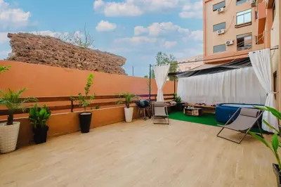 a balcony with chairs and plants on a building at 4BR Duplex - Jacuzzi - 10 min walk to M Avenue with Parking and Pool in Marrakech