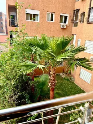 a palm tree in front of a building at Appartement 2 chambres à Marrakech - Résidence Soulaymane, in Marrakech