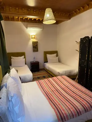 a hotel room with two beds and a chandelier at Riad Zahri 18 in Marrakech