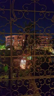 a view of a building through a metal fence at Appartement Majorella Gueliz in Marrakech