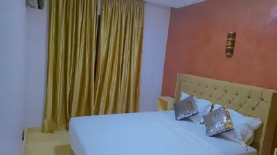 a bedroom with a bed with a yellow curtain at Appartement Majorella Gueliz in Marrakech
