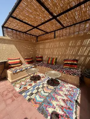 a room with a bed and tables on a rug at Dar Azélia - Charming riad with terrace & pool near Medina in Marrakech
