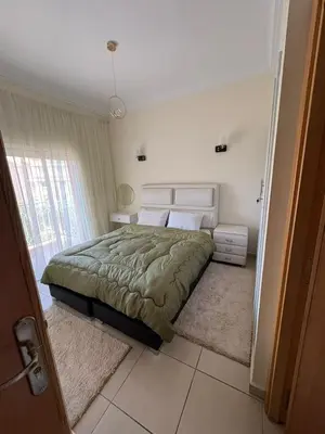a bedroom with a bed and a large window at Les Amandiers in Marrakech
