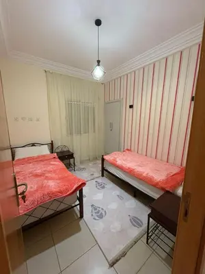 a room with two beds and a rug at Les Amandiers in Marrakech