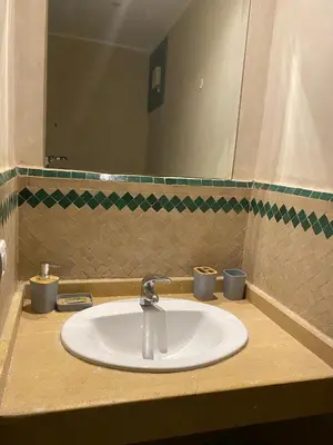 a sink in a bathroom with a mirror at studio au centre ville marrakech calme et confort in Marrakech