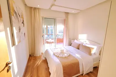 a bedroom with a bed with white sheets and a window at Exceptional stay in Marrakech, Comfort & Style in Marrakech