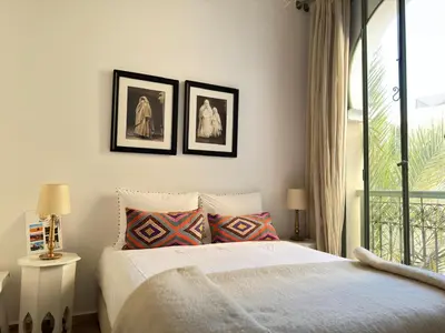 a bedroom with a bed and two pictures on the wall at Riad 29 Mouassine in Marrakech