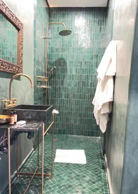 a bathroom with a sink and a shower with green tiles at Riad 29 Mouassine in Marrakech