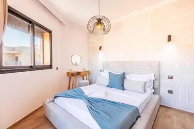 a bedroom with a bed with blue and white pillows at Spacieux 3 Chambres au Cœur de Marrakech in Marrakech