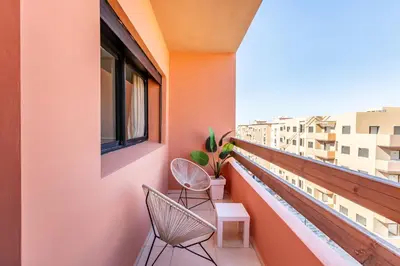 a balcony with two chairs and a window at Spacieux 3 Chambres au Cœur de Marrakech in Marrakech