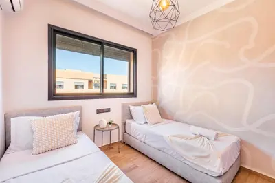 a bedroom with two beds and a window at Spacieux 3 Chambres au Cœur de Marrakech in Marrakech