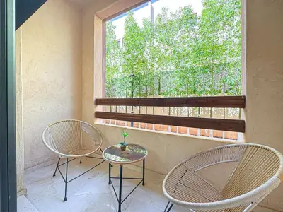 two chairs and a table in front of a window at Cocon à Marrakech avec balcon in Marrakech