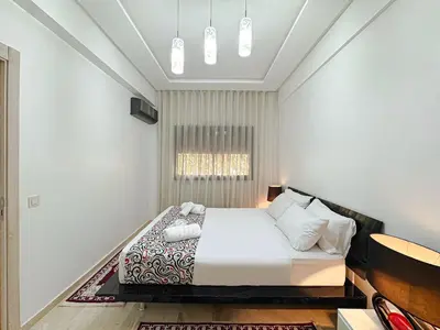 a white bedroom with a bed in a room at Cocon à Marrakech avec balcon in Marrakech