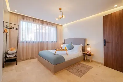 a bedroom with a bed and a large window at Chill Repeat Designer 2BR 2BA In Central Gueliz in Marrakech