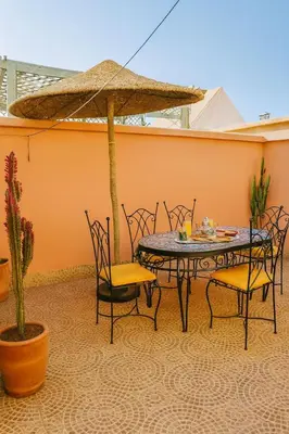 a patio with a table and chairs and an umbrella at Riad Mounad with pool - close to Jemaa el-fna in Marrakech