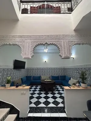 a lobby with a blue couch and a checkered floor at Riad Mounad with pool - close to Jemaa el-fna in Marrakech