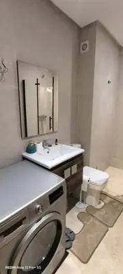 a bathroom with a sink and a washing machine at Appartement moderne au cœur de Marrakech in Marrakech