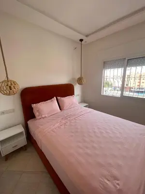 a bedroom with a pink bed with two pink pillows at Apartment Cosy in Marrakech