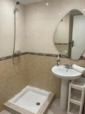 a bathroom with a sink and a shower with a mirror at Apartment Cosy in Marrakech