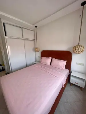 a bedroom with a large white bed with pink pillows at Apartment Cosy in Marrakech