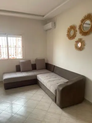 a couch in a living room with a mirror at Apartment Cosy in Marrakech
