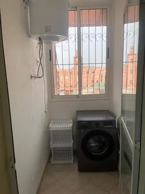 a laundry room with a washing machine and a window at Apartment Cosy in Marrakech