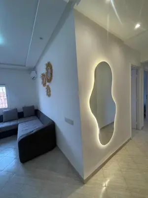 a living room with a couch and a wall with a light at Apartment Cosy in Marrakech