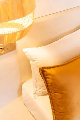 a bed with a pillow and a lamp on it at Central apartment plus jacuzzi in Marrakech