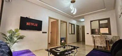 a living room with a tv on the wall at Appartement moderne à louer Marrakech in Marrakech
