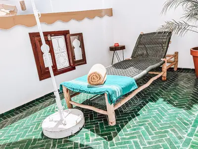a room with a swinging chair and a table at Riad Sharif in Marrakech