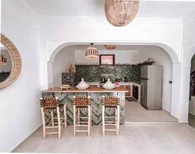 a kitchen with a large island with stools at Riad Sharif in Marrakech