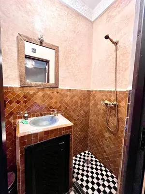 a bathroom with a sink and a mirror at Hotel Jannat in Marrakech