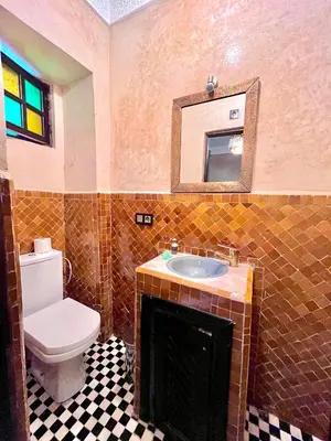 a bathroom with a toilet and a sink and a mirror at Hotel Jannat in Marrakech