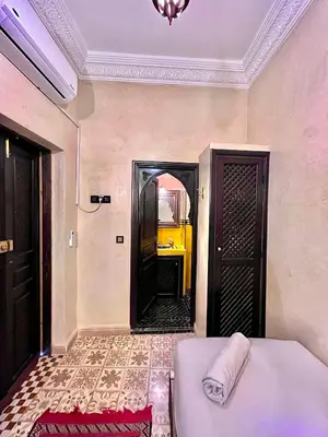 a room with a bed and a hallway with a mirror at Hotel Jannat in Marrakech
