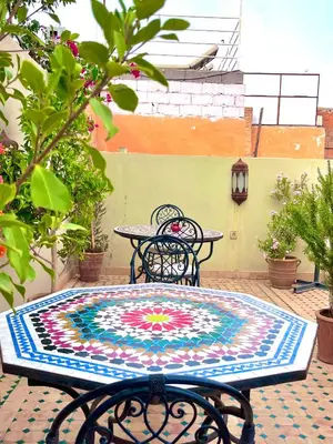 a table and chairs with a colorful rug on a patio at Hotel Jannat in Marrakech
