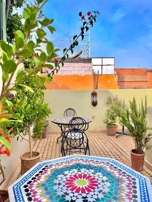 a patio with a table and chairs on a patio at Hotel Jannat in Marrakech