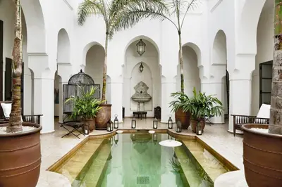 an indoor pool in the middle of a building with palm trees at Dar Mo'Da in Marrakech