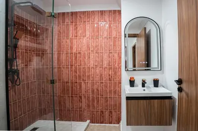 a bathroom with a shower with a sink and a mirror at œil de la vallée in Marrakech