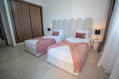 a bedroom with two beds and a large window at œil de la vallée in Marrakech