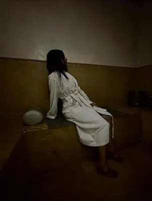 a woman in a white dress sitting on a wall at Asaithic filipina healing hands in Marrakech