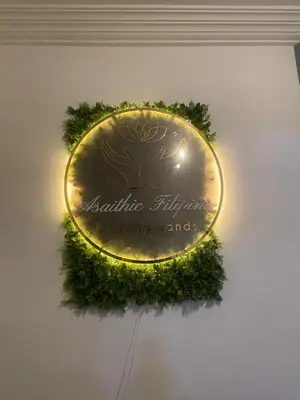 a gold sign on a wall with a green wreath at Asaithic filipina healing hands in Marrakech