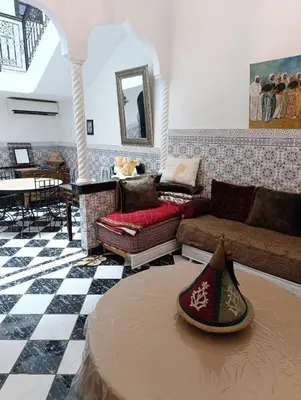 a living room with a couch and a table at Riad kech residence al Qarya syahiya Marrakech in Marrakech